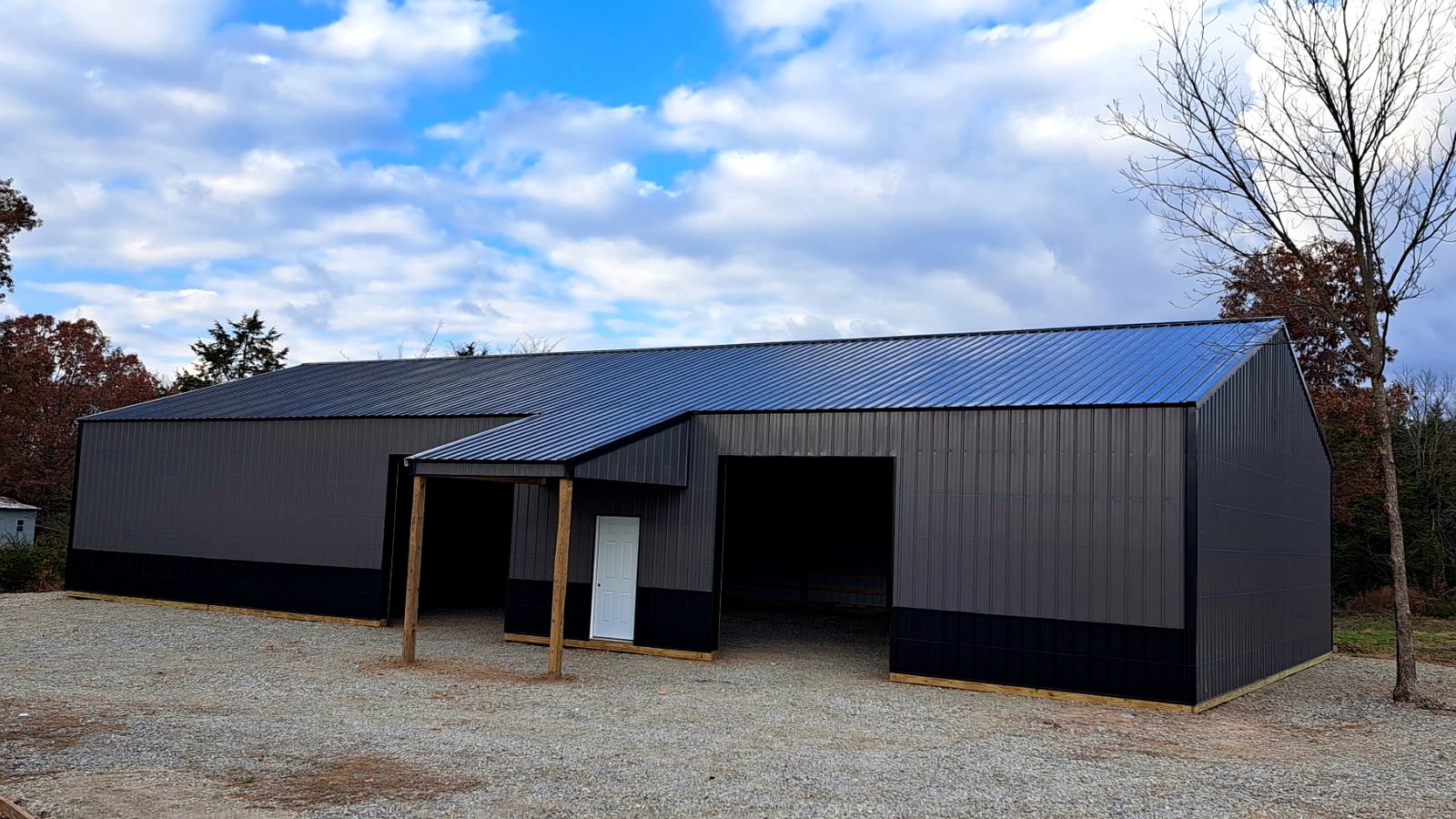 Finished gray post-frame shop building at sunset