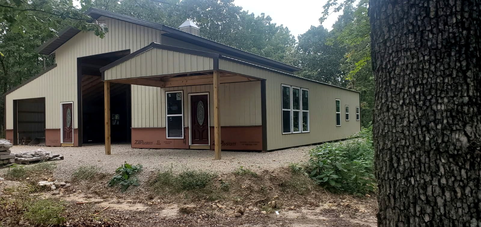 Nichols Construction custom metal-sided building project in a wooded setting