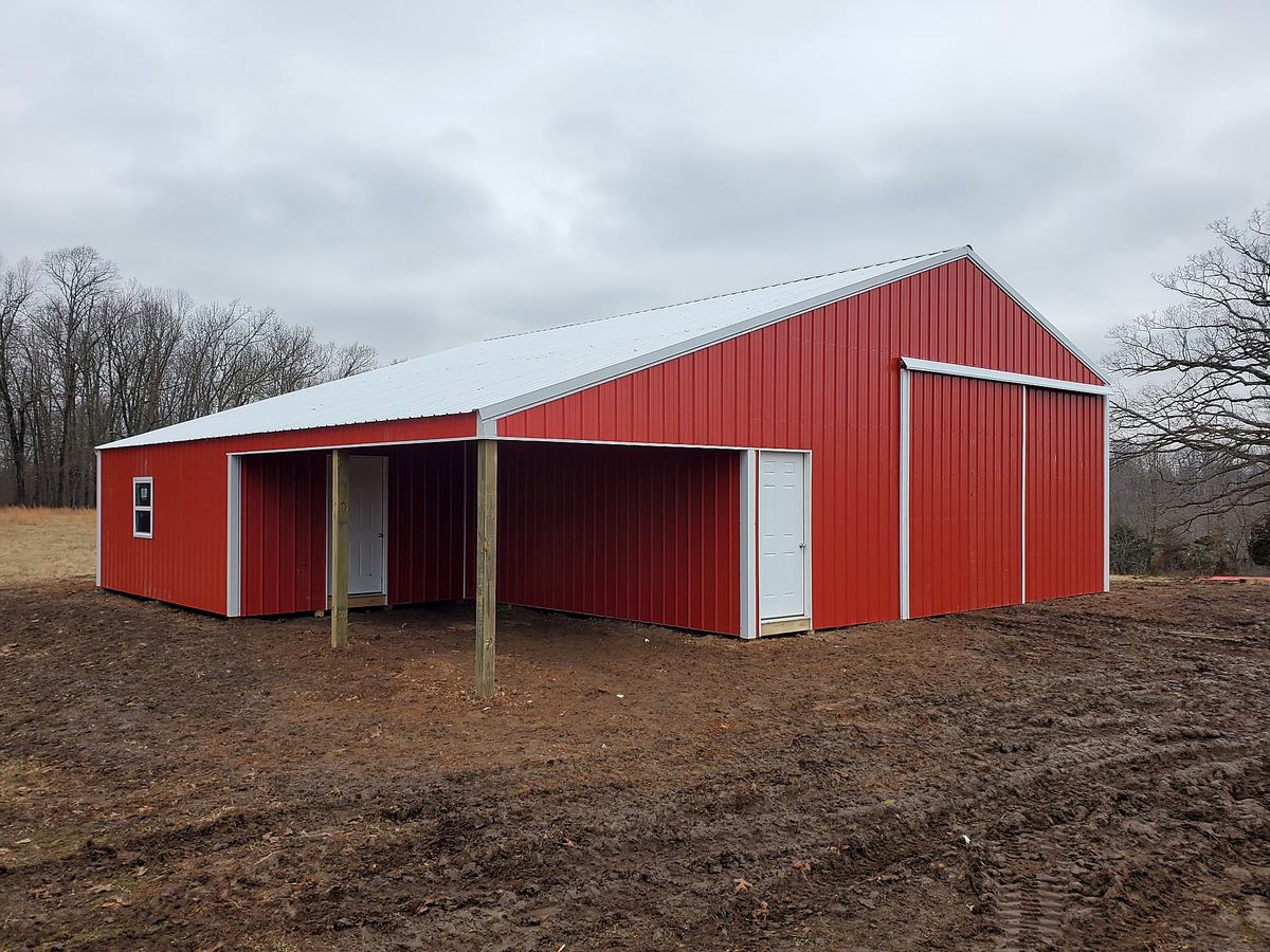 Red pole barn with covered side storage
